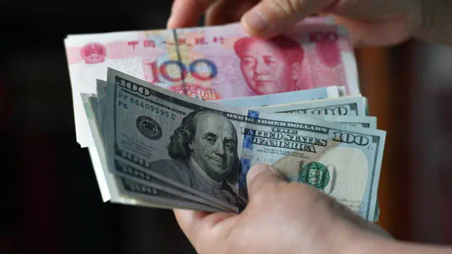 A woman arranges Chinese RMB and US dollars in Fuyang City, Anhui Province, China, Sept 13, 2022